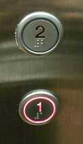The elevator button aperture 32