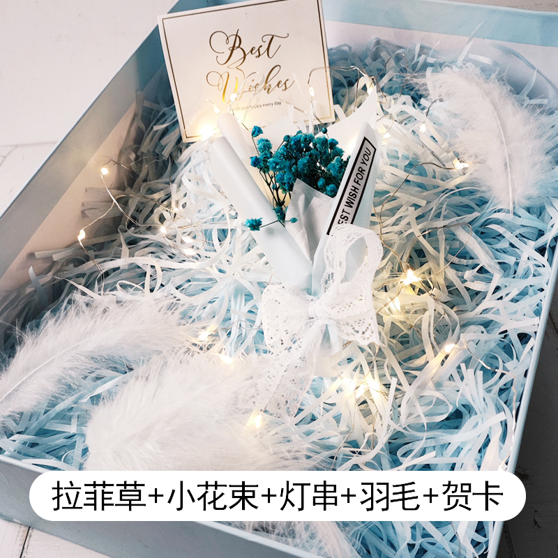The Filling Inside the Gift Box Includes Raffia Grass, Colorful String Lights, Feathers, Fresh Decorative Items, Gift Wrapping Materials, and Dried Flower Bouquets