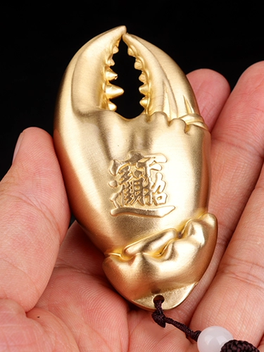 В медной руке есть денежные руки, чтобы положить кусок крабового когтя руку в руку с деньгами, висящими украшения латуни, чтобы сыграть подарки