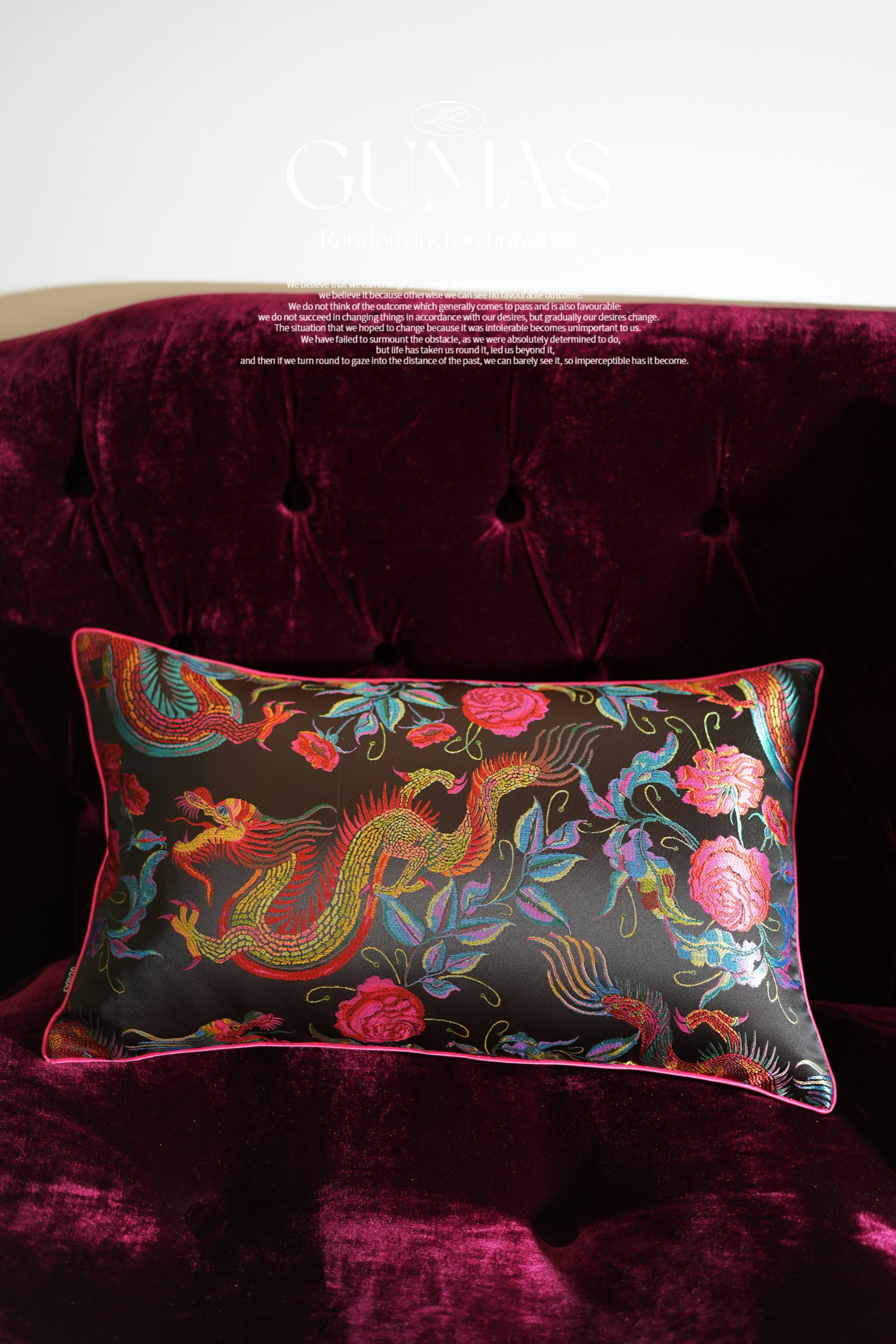 Close-up of metallic gold dragon embroidery with pink roses and blue leaves on black silk panel