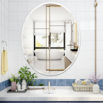 The bathroom oval mirror is attached to the wall and the toilet is round and free of punches