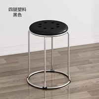 Черная поверхность из четырех столбов и восемь пластиковых табуреток.