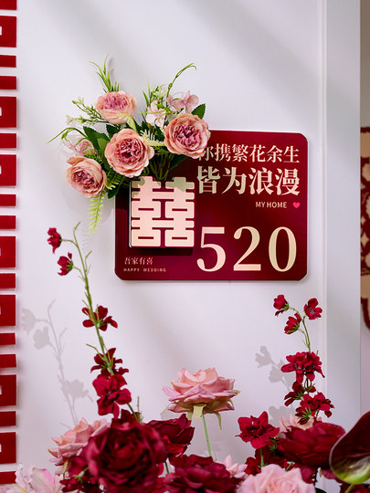 The Newlywed Couple's Bedroom Door Is Decorated with Artificial Flowers to Create a Festive Atmosphere, and the Entrance Door Is Decorated with Wedding Stickers with the Character for Happiness