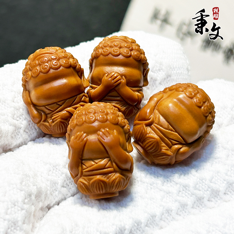 Olive Stone Carving of a Baby Buddha with Four Features That Are Beyond Description, Not to Be Spoken Of, Seen, Heard, or Thought About; a Hand-Twisted Ornament That Is Soft and Flexible for Wearing Around the Finger Olive Stone Carving of a Baby Buddha with Four Features That Are Beyond Description, Not to Be Spoken Of, Seen, Heard, or Thought About; a Hand-Twisted Ornament That Is Soft and Flexible for Wearing Around the Finger