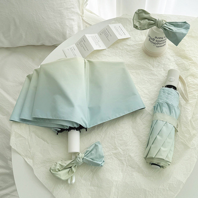 シーソルトブルーのグラデーション傘／日傘、晴れの日も雨の日も使えるデュアルユース、ブラックビニール製の日焼け防止とUVカット機能、自動開閉式、女性向けインスタグラムスタイル。