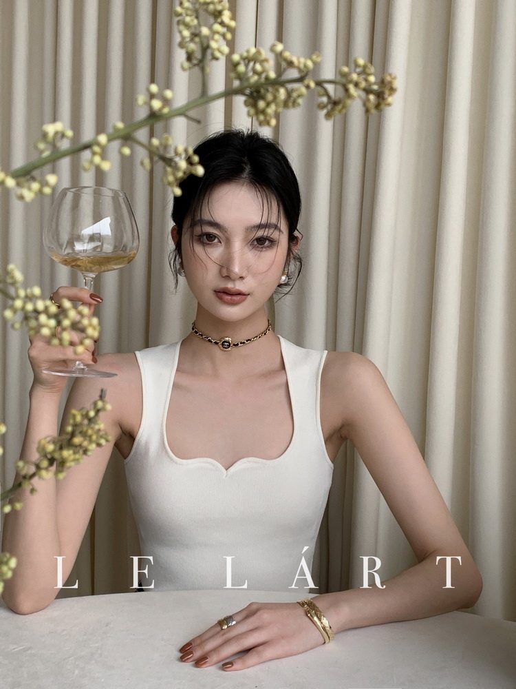 Woman wearing a white sleeveless ribbed top with a square neckline