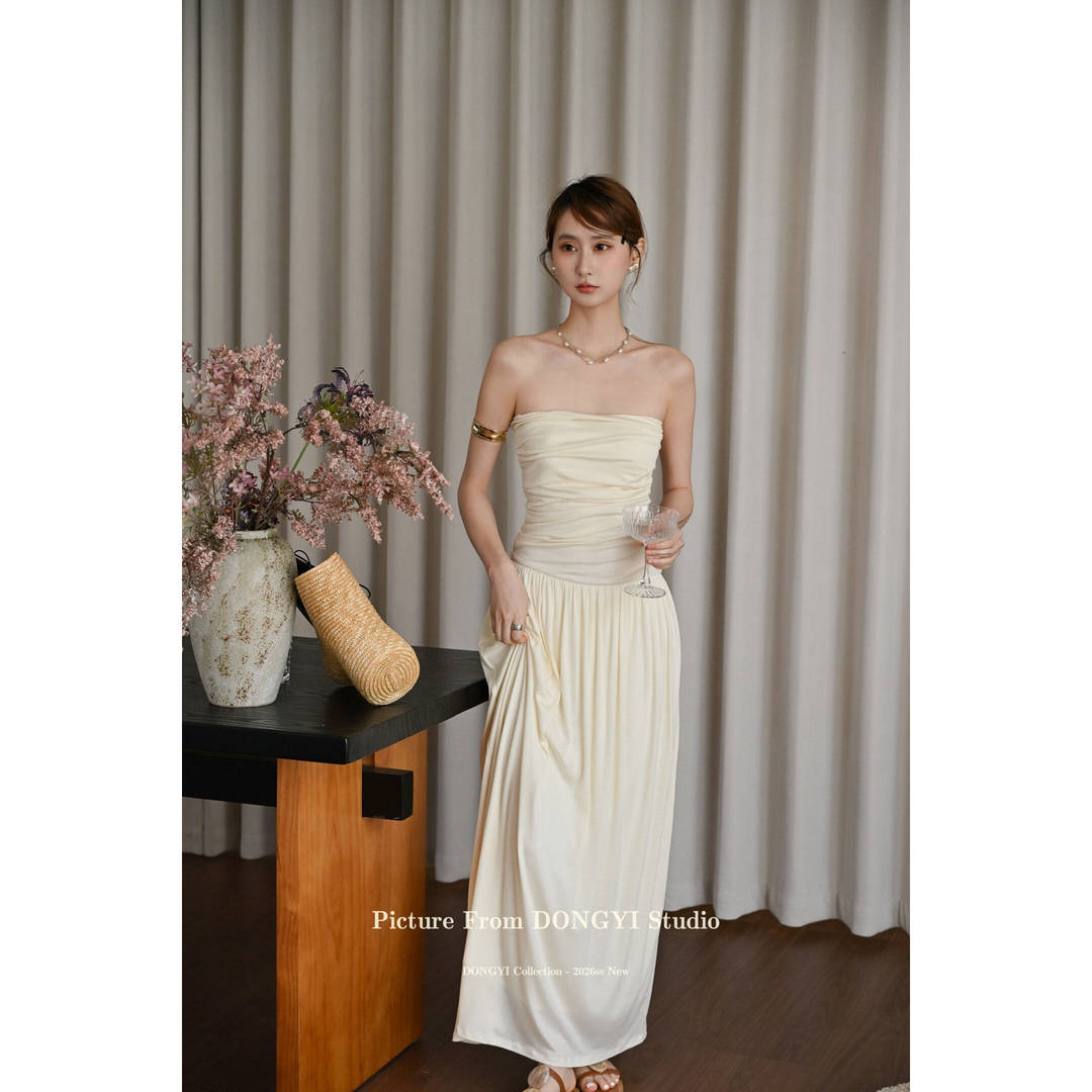 Cream strapless maxi dress worn by a model indoors