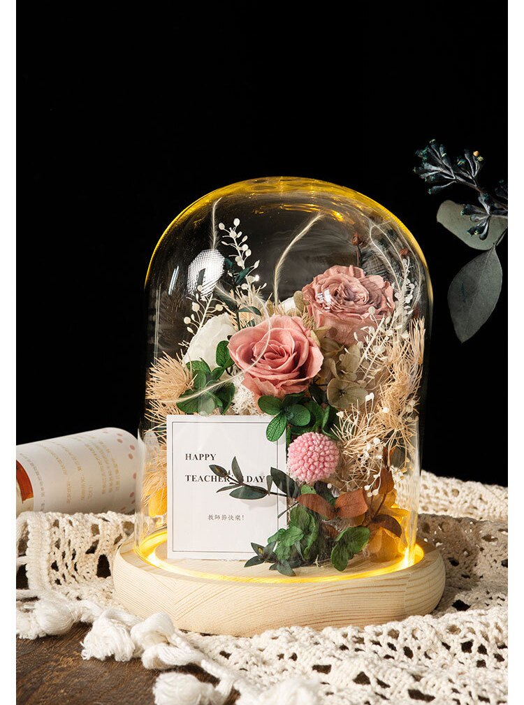 Preserved roses under a glass dome with warm ambient lighting