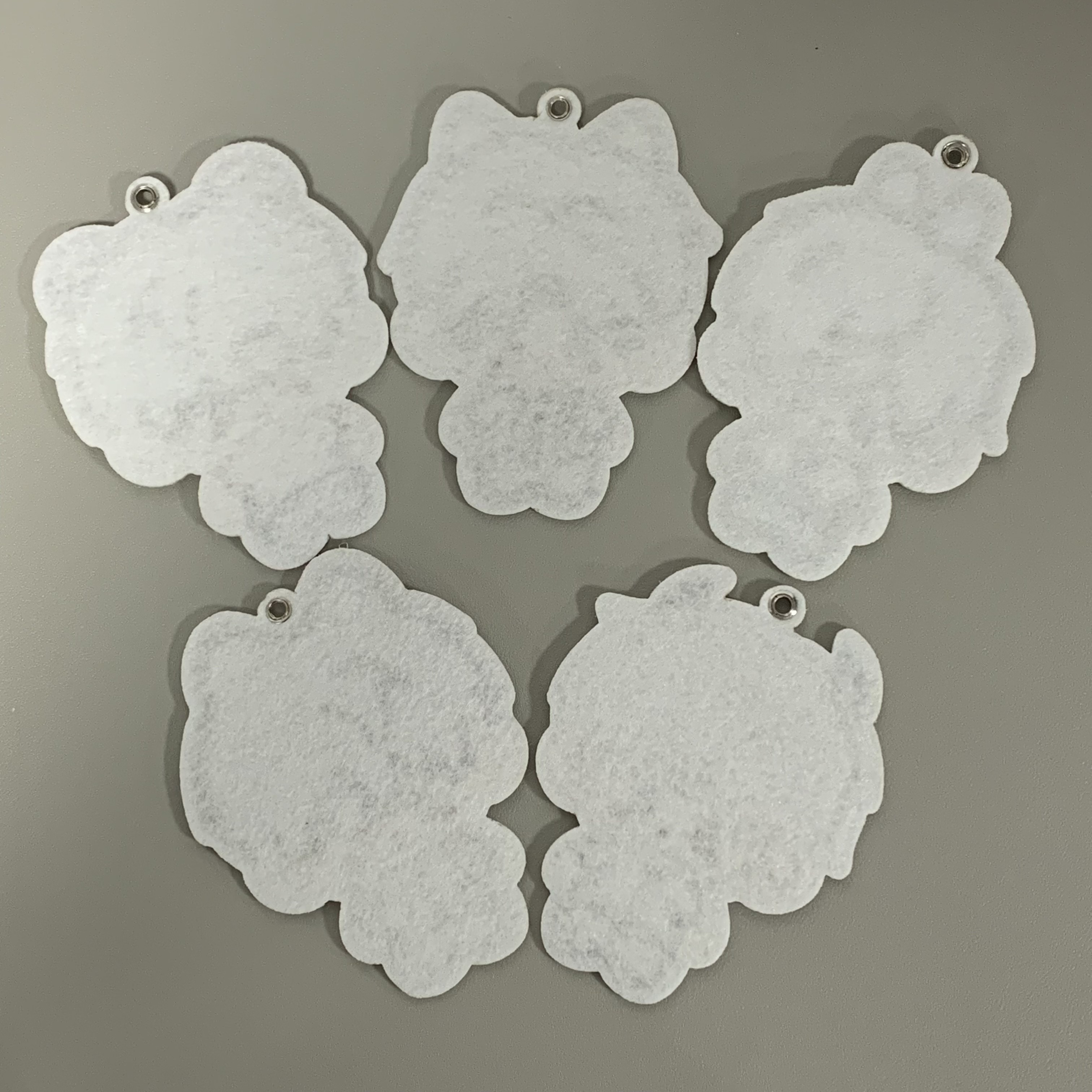 Back view of five Love and Deepspace plush charms with metal eyelets