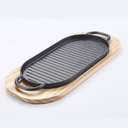 Чугунская выпечка, длинная железная тарелка, небольшие косой линии с рыбным блюдом, блюда из западного пилота для выпекания на бейс -листке для выпека