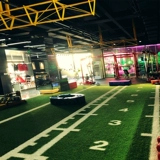 Белая линия взлетно-посадочной полосы на лужайке спортзала в частном классе, индивидуальные масштабные сани, искусственный ковер с искусственным покрытием