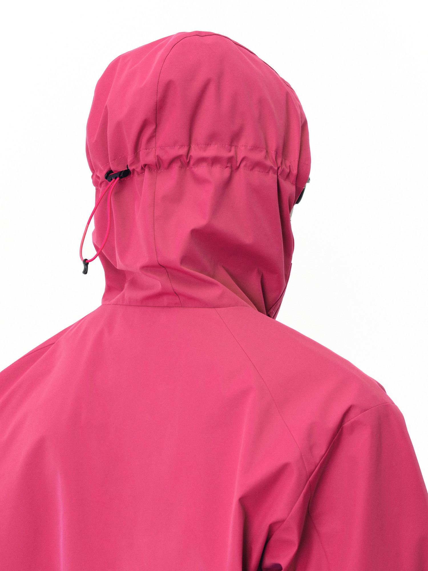 A person is shown from the back wearing EastLyst’s Best All-Rounder Jacket in bright pink, featuring a hood and black adjustable drawstring. The lightweight packable jacket stands out against a plain white background.