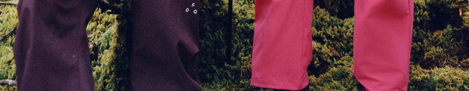 Four EastLyst 3-in-1 Color-Block Storm Jackets in dark purple and pink hang side by side over a mossy branch in the forest, ready for any adventure or urban commute with all-weather protection.