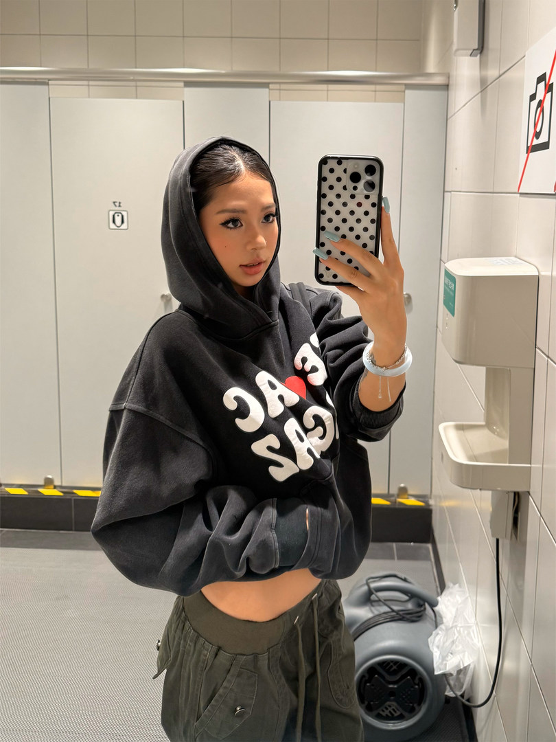 Woman wearing an oversized black graphic hoodie with casual cargo-style pants