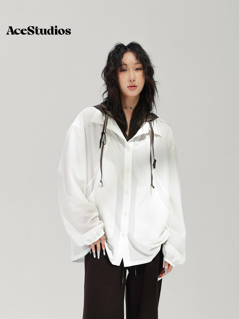 Model wearing a loose white button-up shirt with black pants