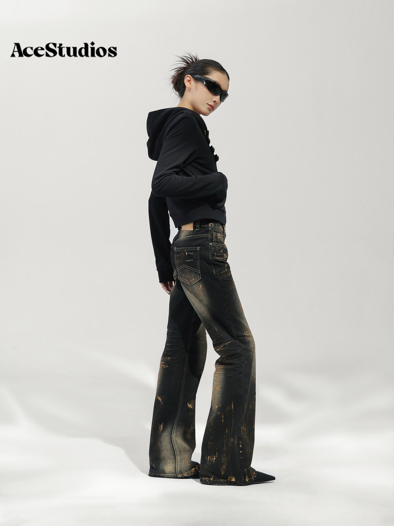 Model wearing a black hoodie and embellished black flared jeans.