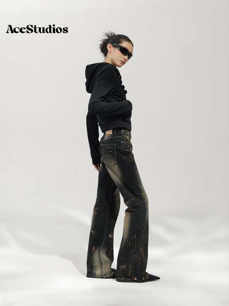 Model wearing a black hoodie and embellished black flared jeans.
