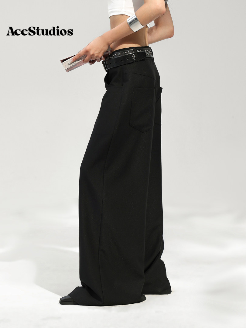 Model wearing wide-leg black pants with a studded belt.