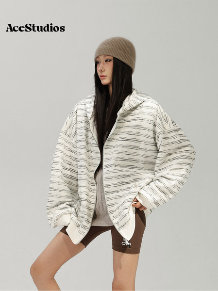 Model wearing an oversized textured white jacket with a knit beanie