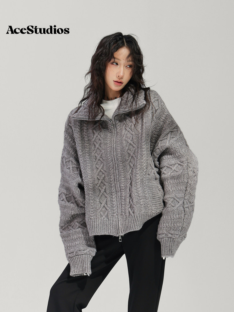 Model wearing an oversized gray textured knit sweater with black pants