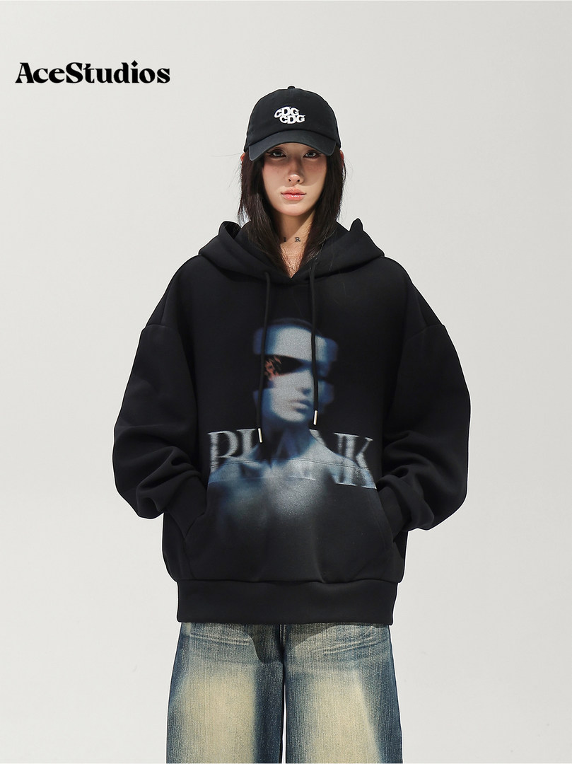 Model wearing a black oversized graphic hoodie and black baseball cap.