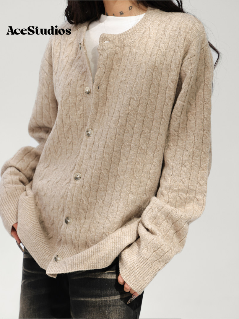 Model wearing a beige cable-knit button-front cardigan.