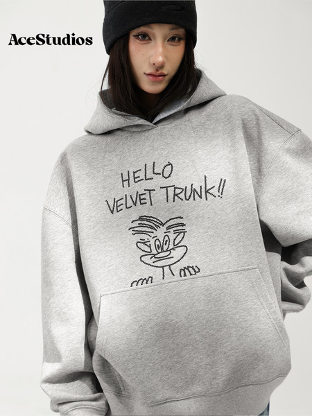 Model wearing a gray graphic pullover hoodie with a kangaroo pocket.