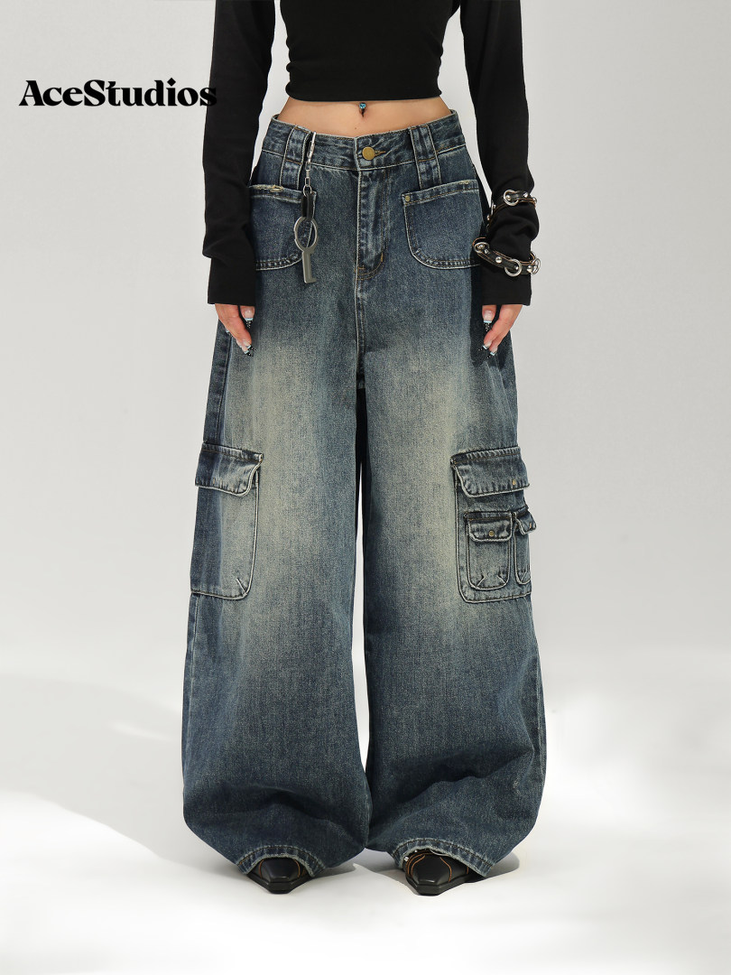 Model wearing oversized distressed blue cargo jeans with wide legs and multiple pockets.