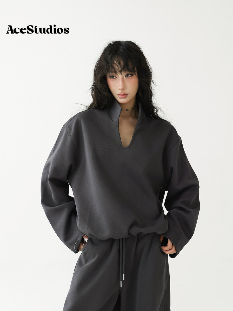 Model wearing a black oversized long-sleeve pullover and matching drawstring pants.