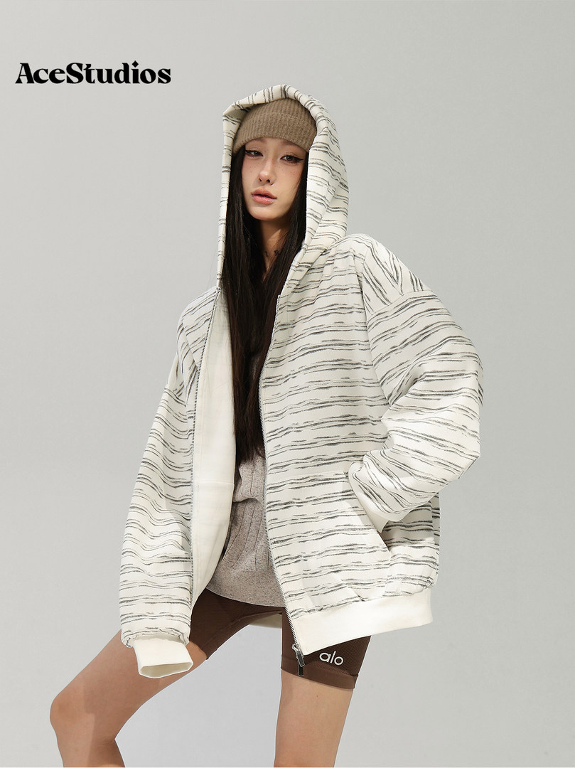 Model wearing an oversized white-and-gray striped hooded jacket.