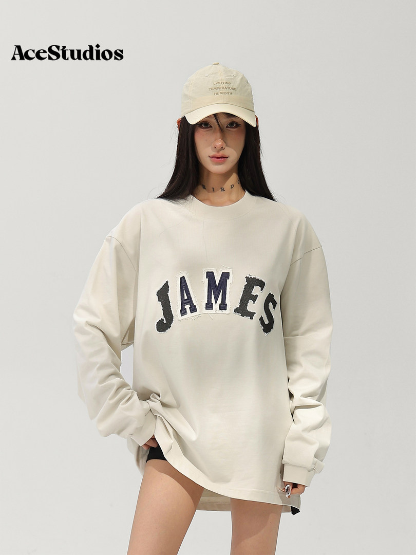 Model wearing an off-white oversized graphic sweatshirt with a baseball cap.