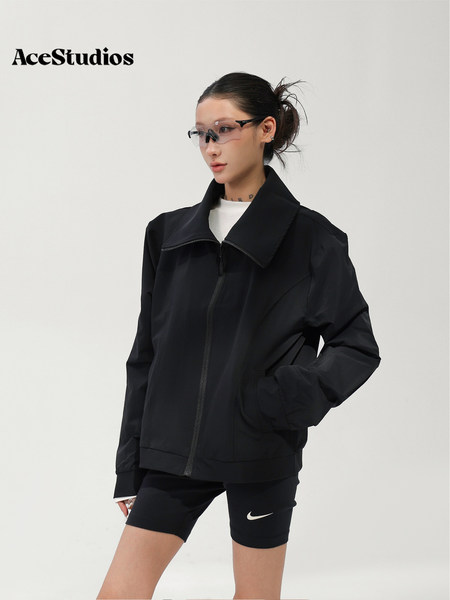Model wearing a black zip-up jacket with an oversized collar