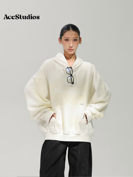 Model wearing an off-white oversized hoodie with black pants.