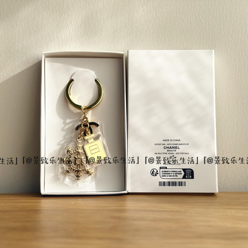 The Fragrance Counter Offers a Gift: a New Golden Snowflake Bottle Keychain with a Combination of Three Elements. Counter Gift