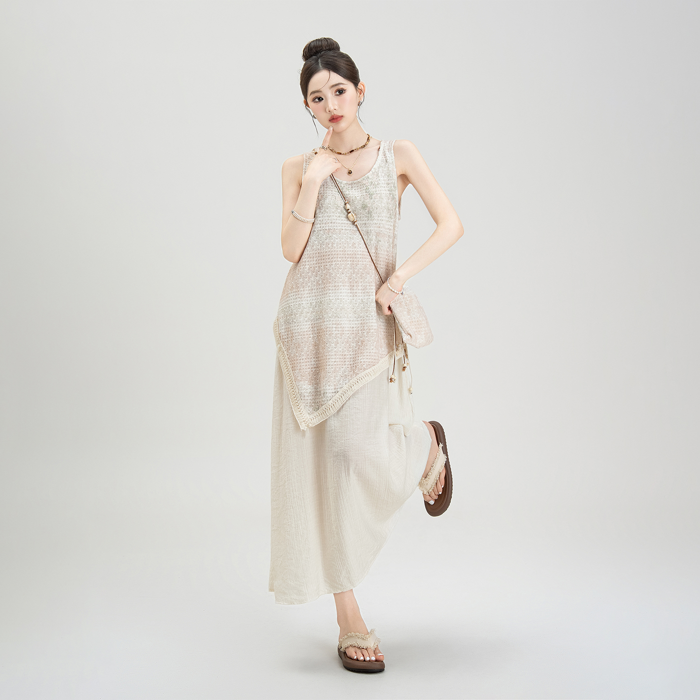 アプリコット色の不規則な絞り染めのノースリーブベストサスペンダードレス。夏に活躍するレディース向け。フェイクツーピースのゆったりとしたスリムなロングスカート。