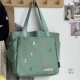 Вышивка зеленых букв из фасоли