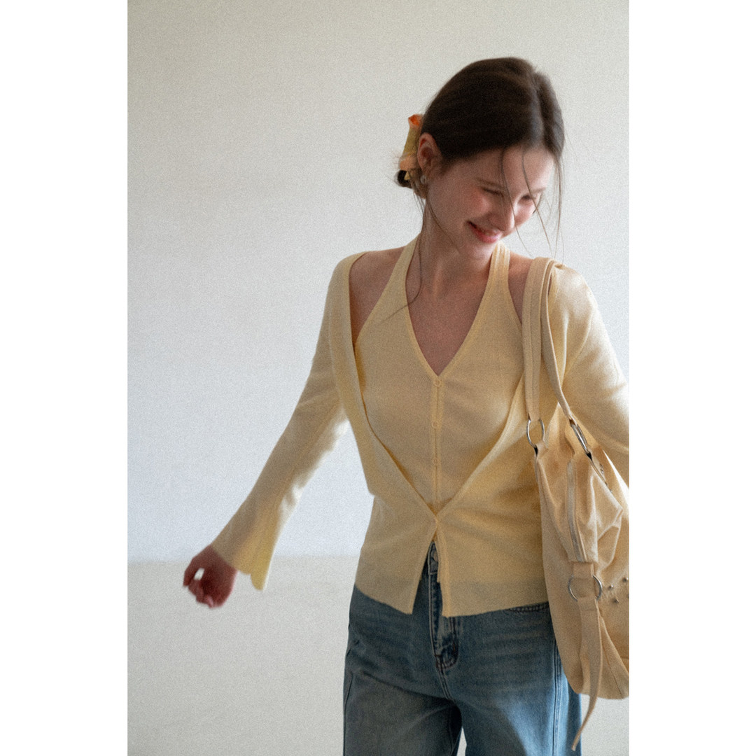 Light yellow knit cardigan worn by a model with jeans and a shoulder bag