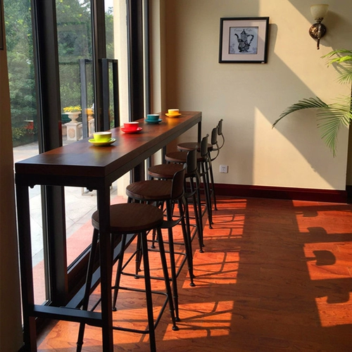 Американский железный сплошной древесина. Домохозяйственное столик, стул в молочный чайный магазин против стены на столе настольной столешницы с высоким содержанием стола и стула