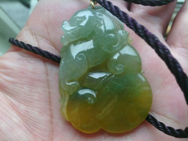 Three-color emerald pendant in the light of an emerald