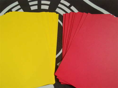 Даосский поставляет желтые часы с бумагой пустой стол и бумага на столе.