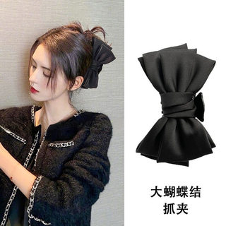 Celebrity style black bow hairpin on the back of the head