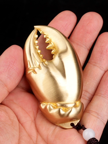 В медной руке есть денежные руки, чтобы положить кусок крабового когтя руку в руку с деньгами, висящими украшения латуни, чтобы сыграть подарки