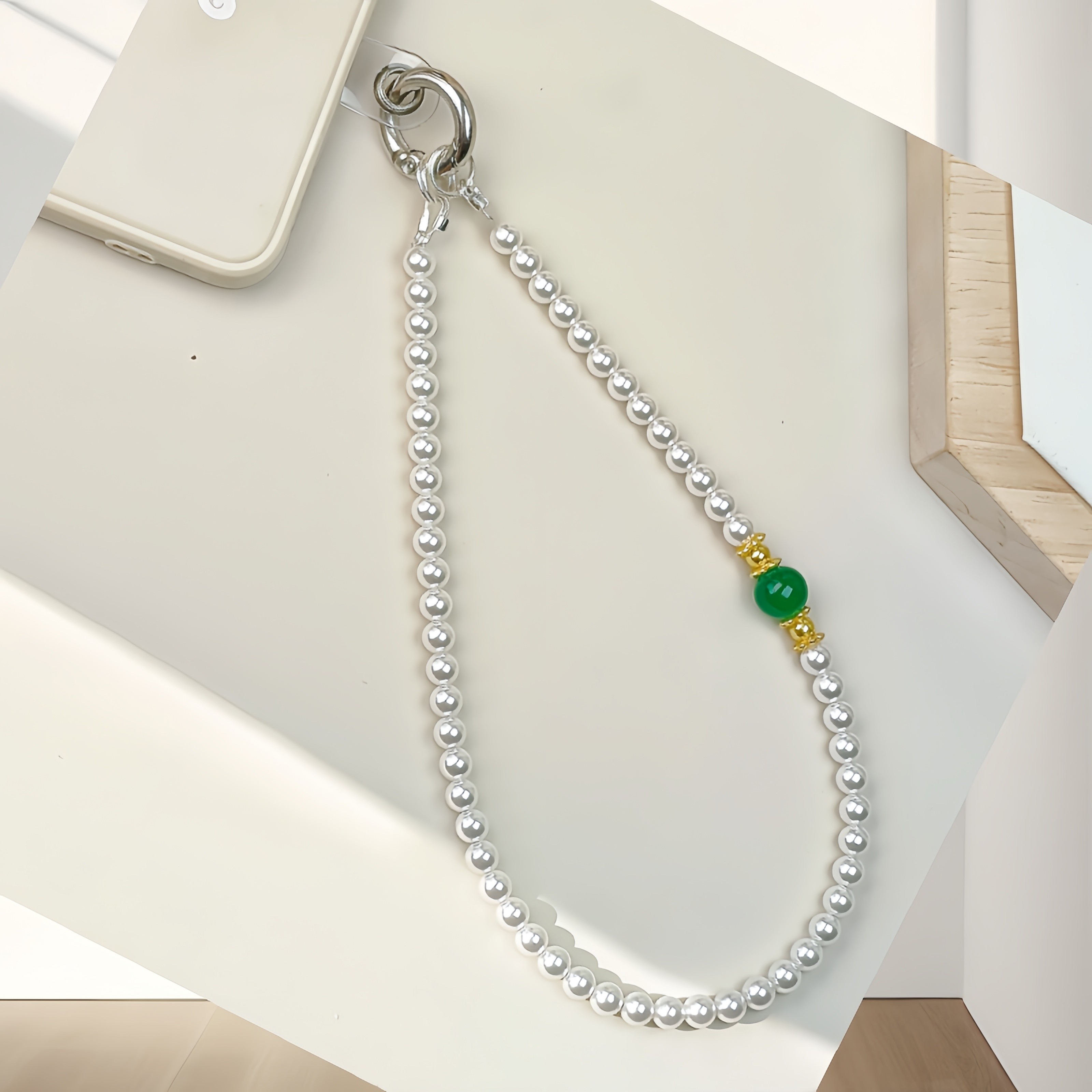 An elegant and simple handmade freshwater pearl phone charm by an older woman, sturdy and anti-loss, a touch of luxury for phones and keys.