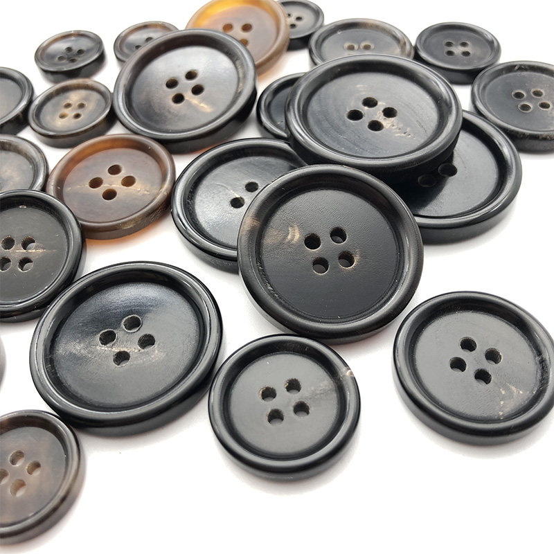 天然輸入本革ホーンボタン、高級ブラックスーツ用4つ穴ボタン、カジュアルスーツ用メンズトレンチコートボタン。