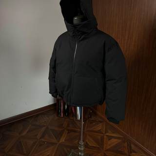 Die mehrfach verstellbare daunenjacke von oclin mit kapuze ist winddicht und wasserabweisend, hat eine dekonstruierte silhouette und besteht zu 90 % aus weißen entendaunen