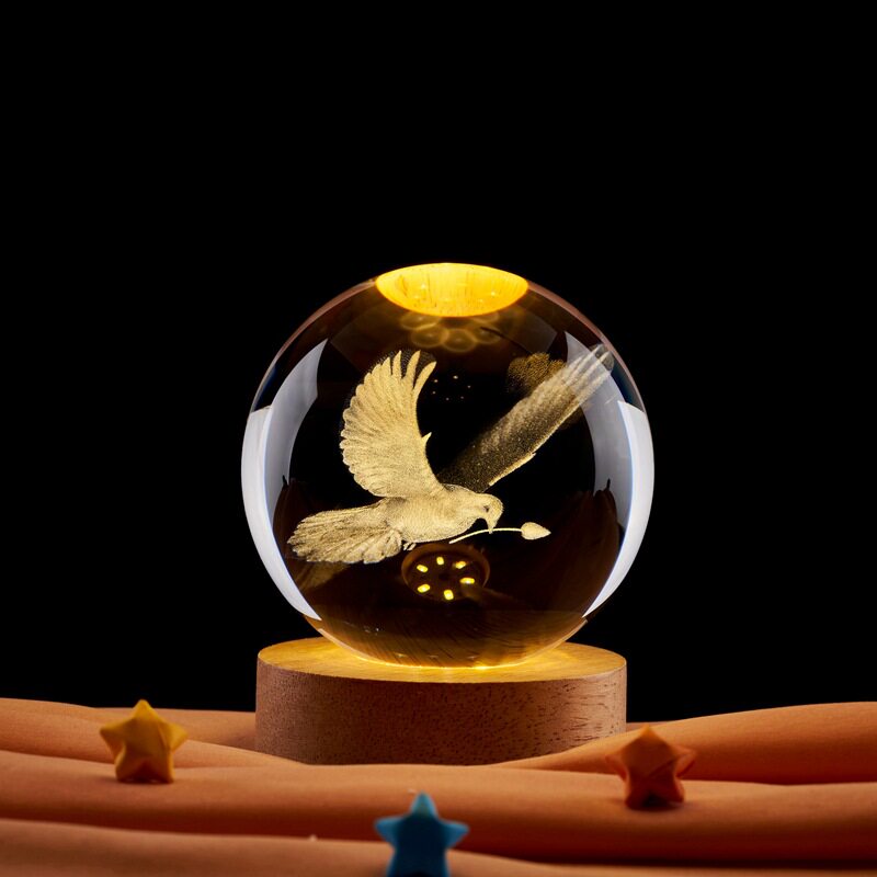 3Dレーザー彫刻が施されたクリスタルボールの鳩型ナイトライトは、お祝いの雰囲気を演出するクリエイティブな装飾品です。