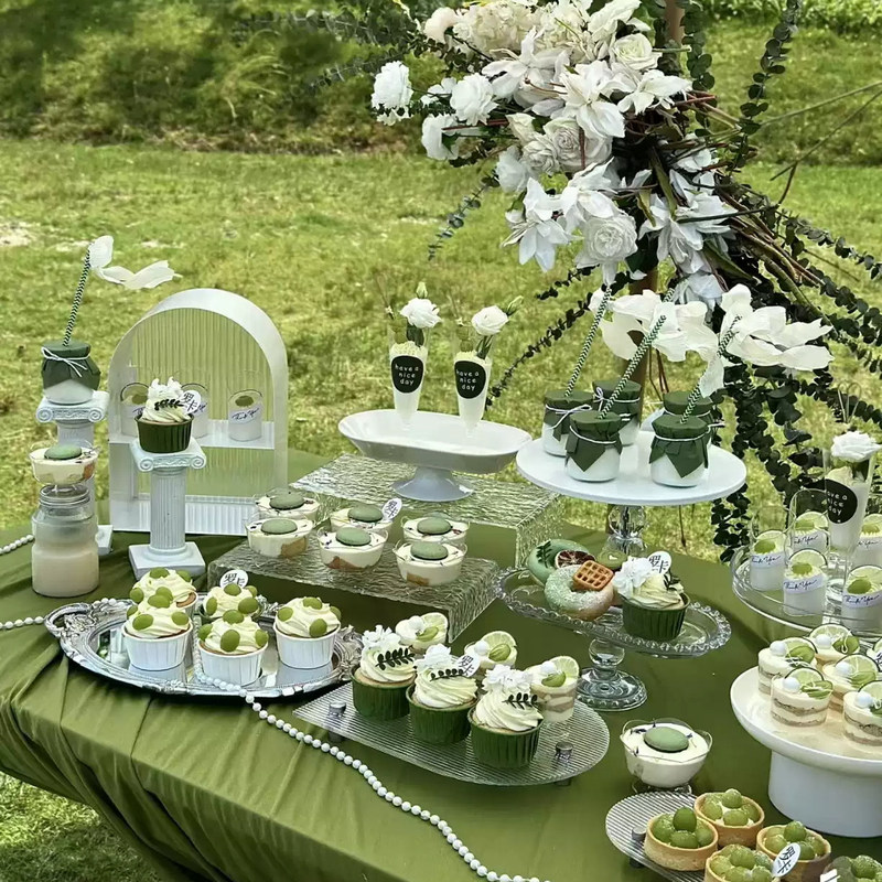 White and Green Forest-Themed Dessert Table Display Stand for Outdoor Tea Break Dessert Table Setup White and Green Forest-Themed Dessert Table Display Stand for Outdoor Tea Break Dessert Table Setup