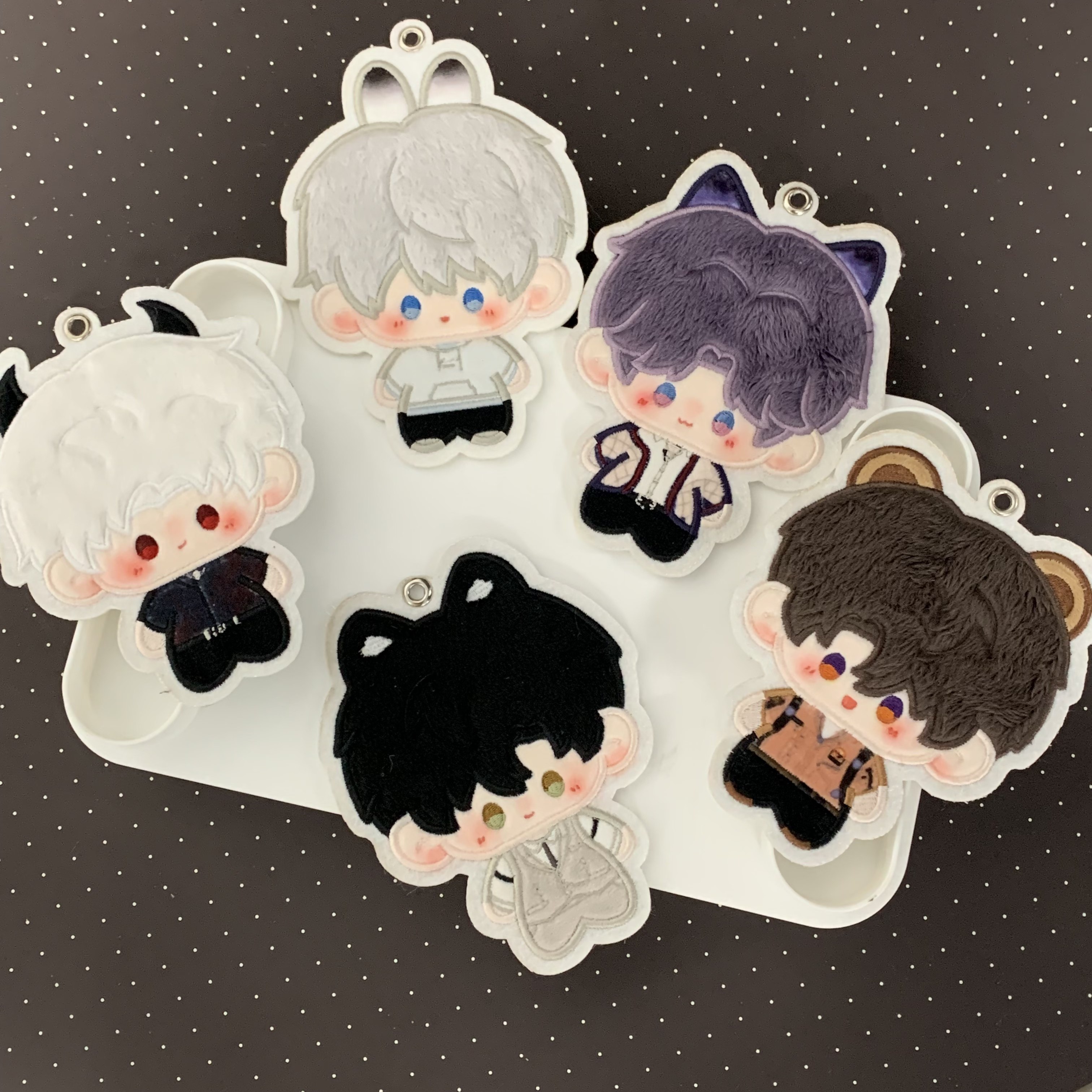 Love and Deepspace embroidered character charms displayed together