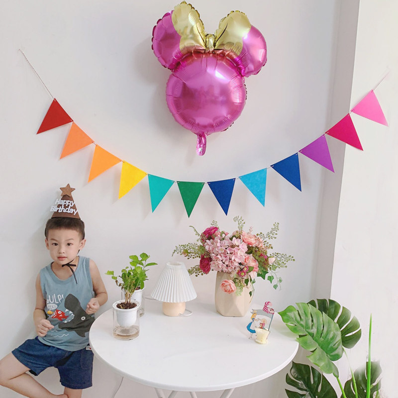 Nonwoven colored triangle children's birthday party arranged with colorful background drawn flower decoration children's room arrangement