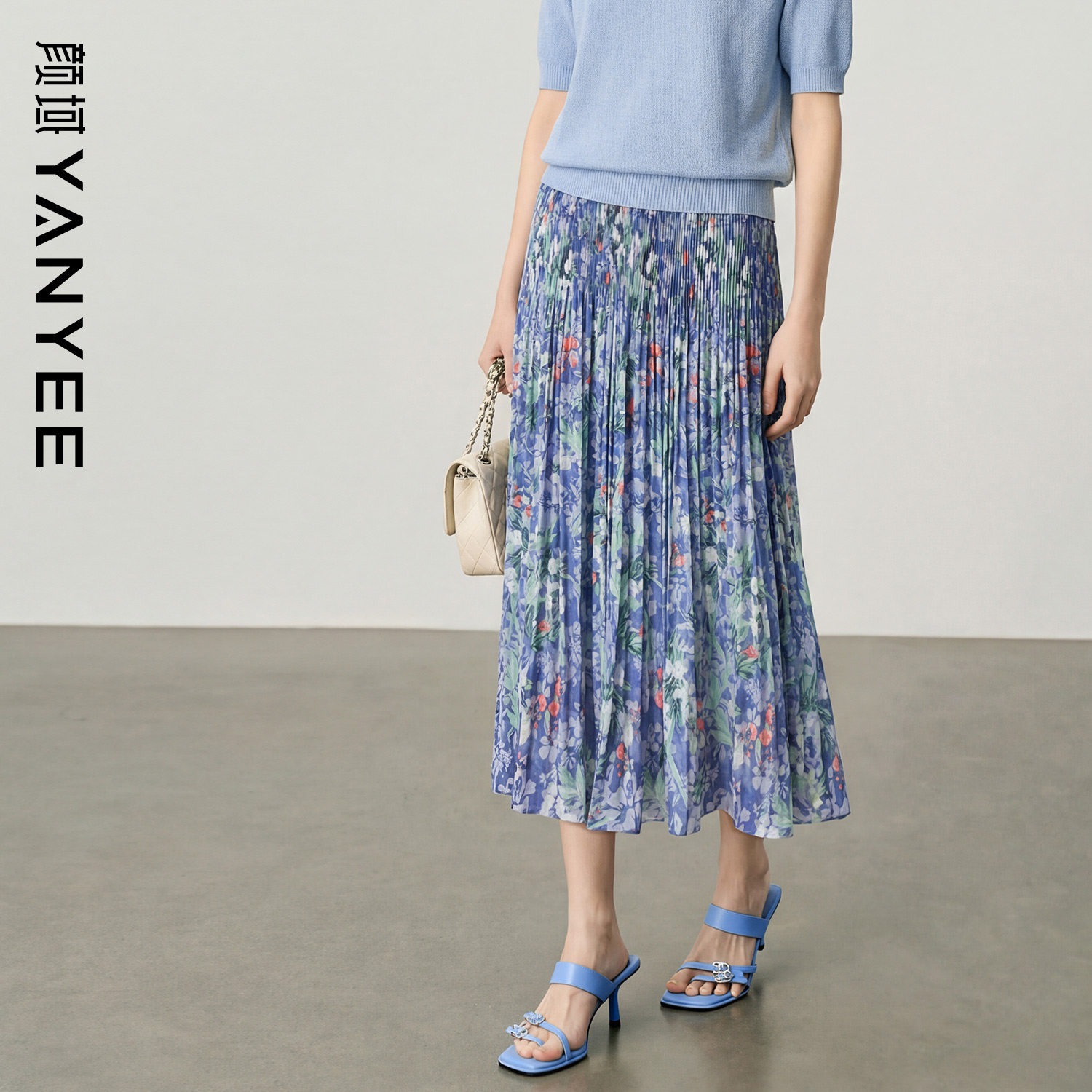 ヤン・ユーの息を呑むほど美しい花柄プリントのミディスカートは、2026年夏の新作スタイルで、体型を美しく見せる洗練されたAラインシルエットが特徴で、膝下まで丈があります。